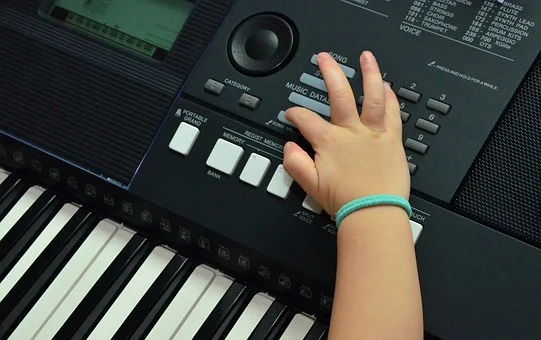 Op zoek naar een instrument voor je kInd? Kinderhand drukt toets keyboard.